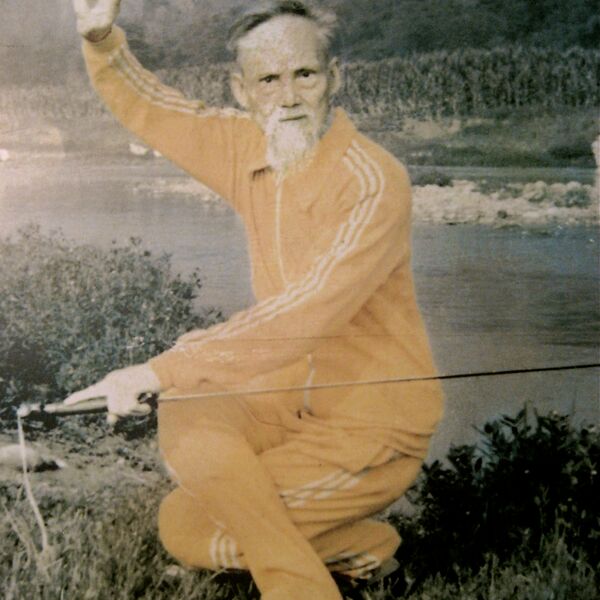 The venerable Master Liu XIn Wu, lineage holder of Zi Ran Men Qi Gong in the 5th generation with a sword in a crouching Kung Fu position