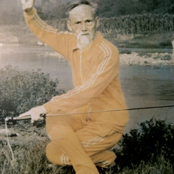 Der ehrwürdige Meister Liu Xin Wu, Linienhalter des Zi Ran Men Qi Gong in der 5. Generation hockend mit einem Schwert in einer Kung Fu Position